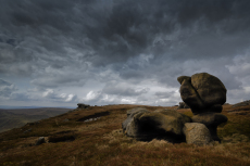 A boulder of Carboniferous age, Millstone Grit eroded and carved by the action of rain and ice, the Kinder Scout Plateau, Edale, Derbyshire, England, UK, April
