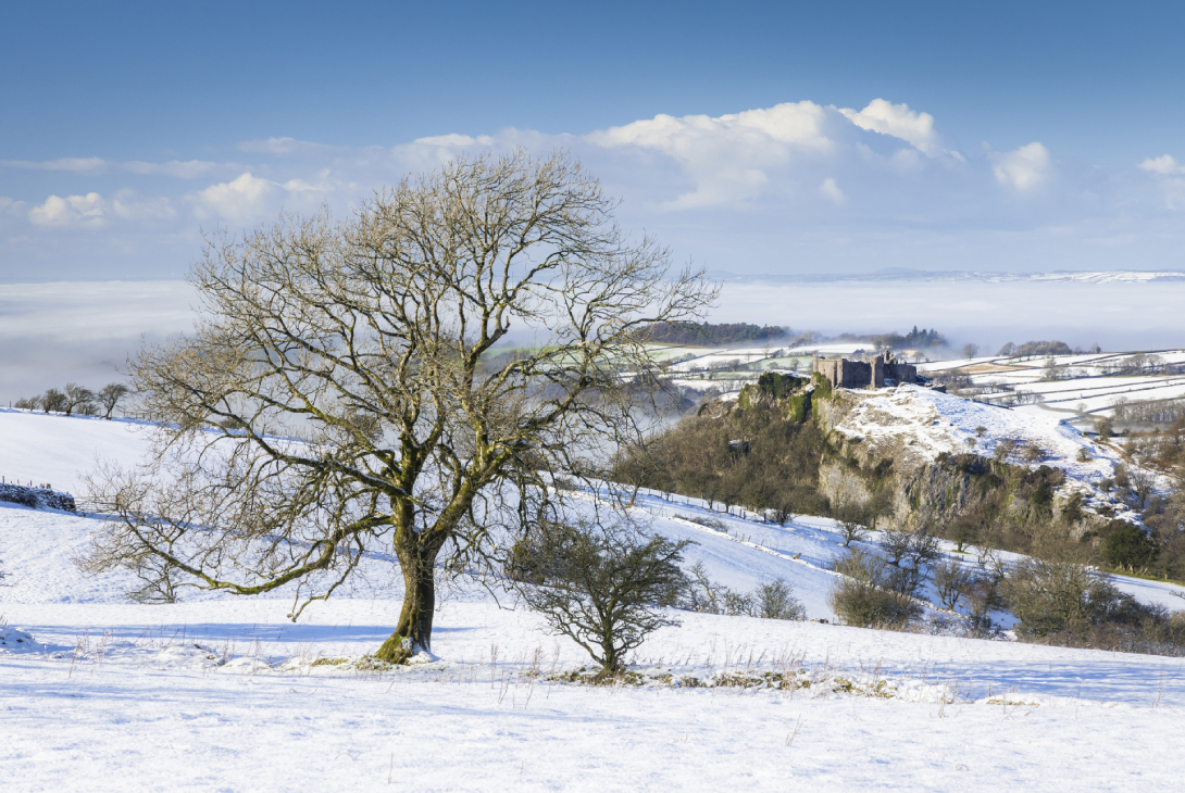 Snow and low cloud across the Carmarthenshire countryside at Carreg Cennen Castle in winter, Carmarthenshire, Western Brecon Beacons, Wales, UK, January
